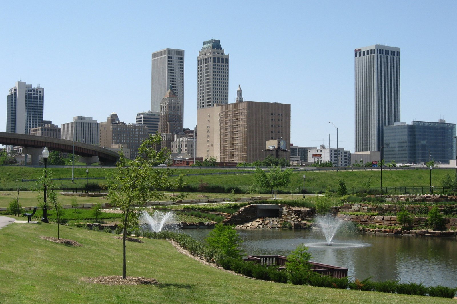 Downtown Tulsa skyline behind green lawns and fountains